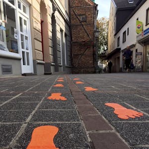 Im Rahmen des Projekts „Bespielbare und besitzbare Stadt“ wurden auf dem Pflaster der Kirchstraße farbige Fußspuren aufgebracht. Sie sollen Kinder zum Hüpfen animieren.