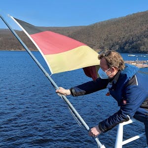 Die Flagge hissen: Martin Conzelmann bringt die Deutschlandfahne am Heck der Stella Maris an. Ab diesem Samstag wird sie im Fahrtwind wehen.