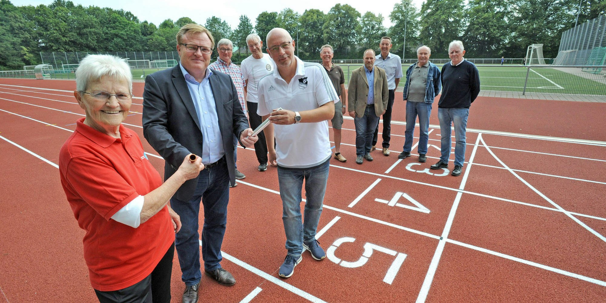 Ingeborg (Iko) Kaftan, Stefan Caplan, Bernd Hammans mit den Staffelstäben auf dem neuen Platz.