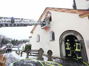 Mit Hilfe einer Drehleiter kontrollierten Feuerwehrleute den Dachstuhl der Kirche nach Glutnestern.