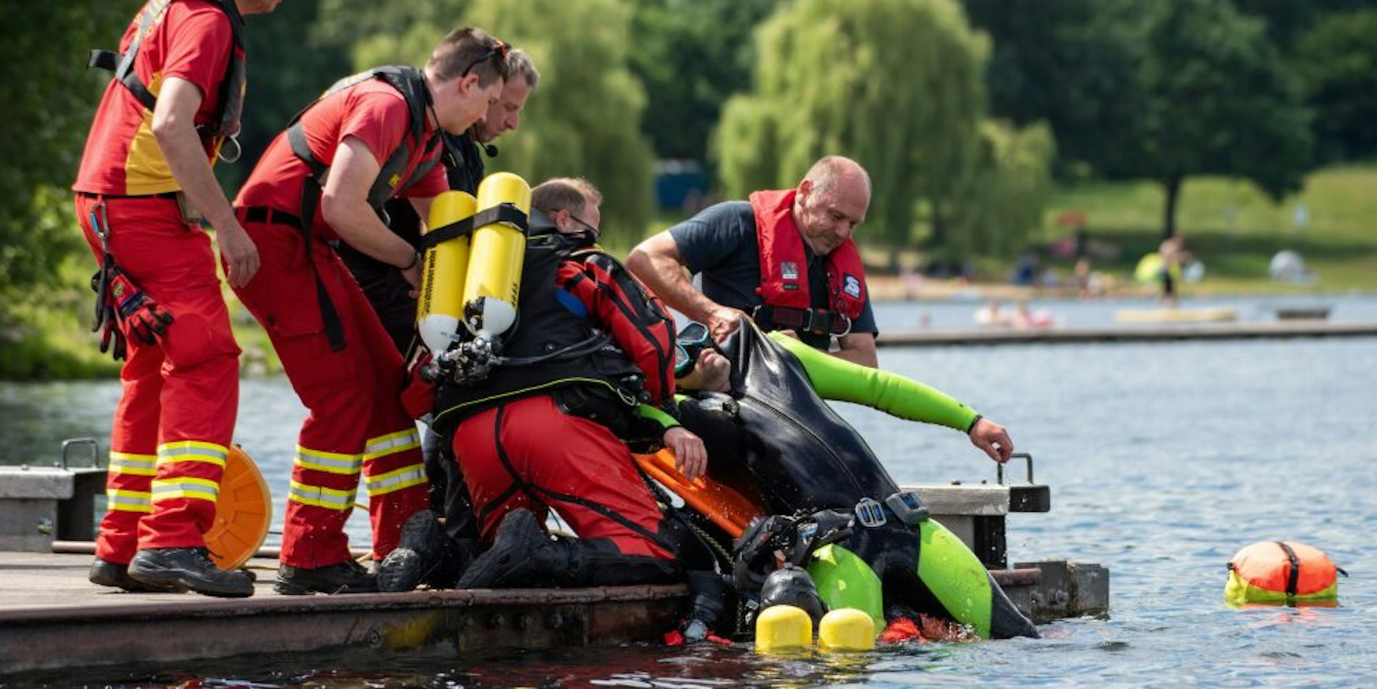 Übung am Fühlinger See: Ein Taucher simuliert einen Ertrinkenden, der von Feuerwehr und DLRG aus dem Wasser gezogen wird.