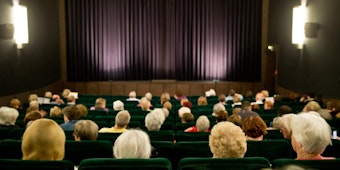 Senioren sitzen in einem Kino