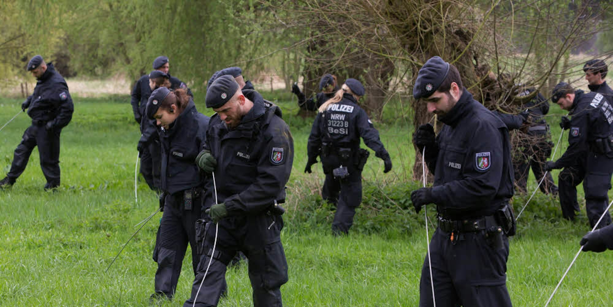Polizisten durchkämmen das Gebiet in der Siegaue, in dem eine Frau vergewaltigt wurde.
