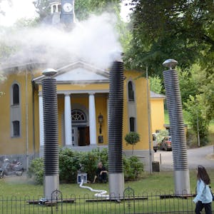 Mancher dachte schon, die Kirche brenne: Ein echter Blickfang sind die drei dampfenden Säulen vor der Evangelischen Gnadenkirche in Gladbach – und ein Mahnmal.
