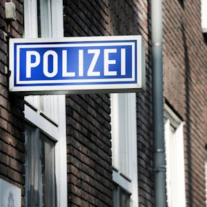 Die Polizeiwache in Mülheim/Ruhr: Die Backstein-Fassade ist zu sehen, daran montiert ein blau-weißes Schild mit der Aufschrift Polizei.