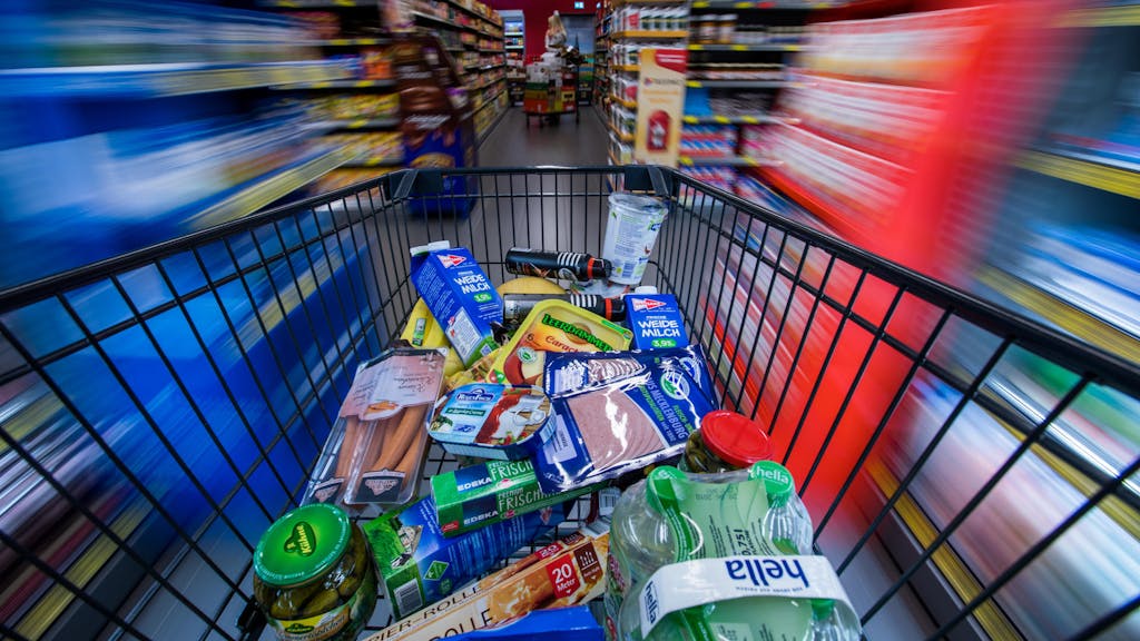 Lebensmittel und andere Waren in einem Einkaufswagen.