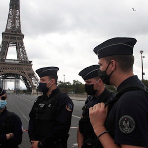 Polizisten stehen vor dem Eiffelturm in Paris