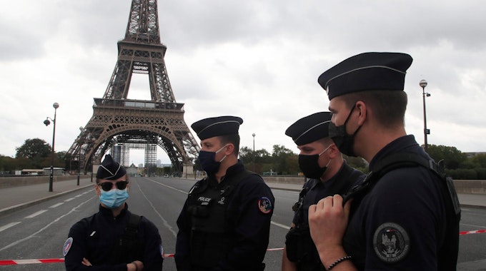 Polizisten stehen vor dem Eiffelturm in Paris