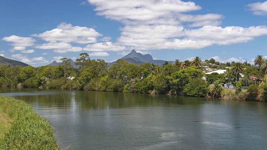 Tweed River und Mount Warning, früher ein Vulkan. Seinen Namen (Berg Warnung) erhielt er vom Entdecker James Cook, der damit nach ihm kommende Schiffe auf gefährliche Gewässer aufmerksam machen wollte. Murwillumbah, New South Wales, Australien.