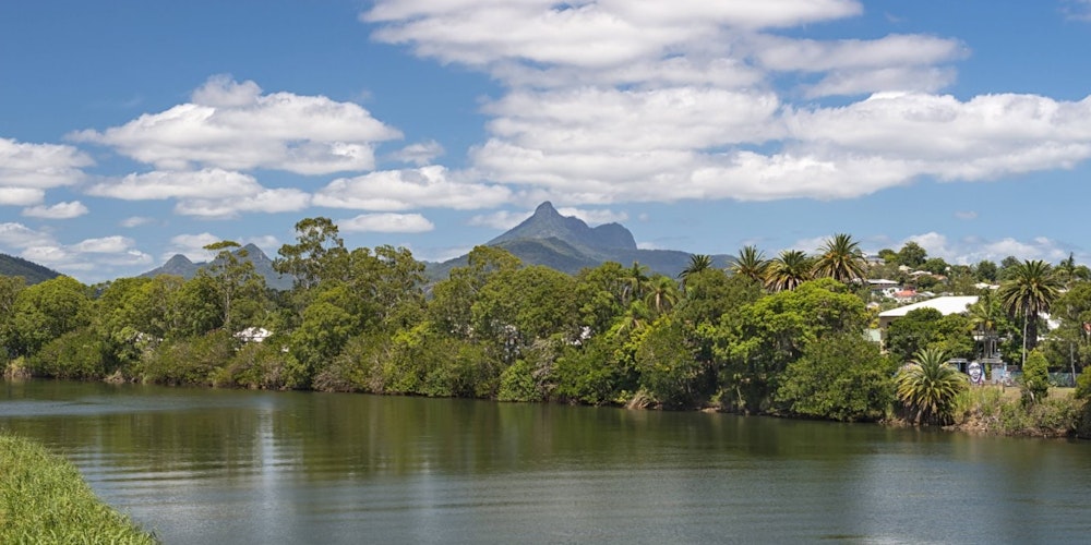Tweed River und Mount Warning, früher ein Vulkan. Seinen Namen (Berg Warnung) erhielt er vom Entdecker James Cook, der damit nach ihm kommende Schiffe auf gefährliche Gewässer aufmerksam machen wollte. Murwillumbah, New South Wales, Australien.