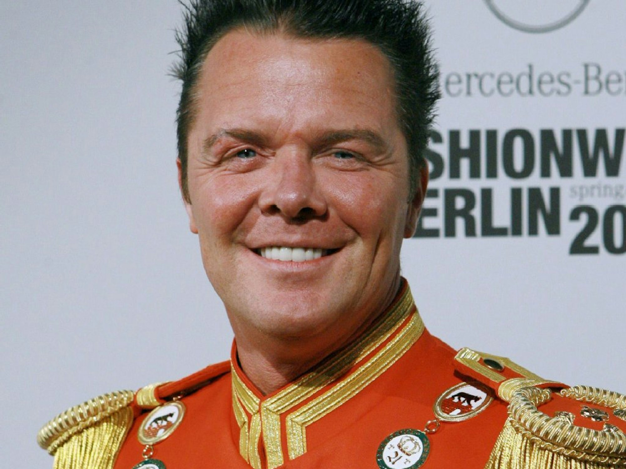 Prinz Marcus von Anhalt posiert mit einer roten Uniform.