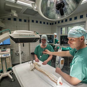 Professor Leonard Bastian und Dr. Jan Siewe demonstrieren in einem Operationssaal des Klinikums ihre neue digitale Technik.