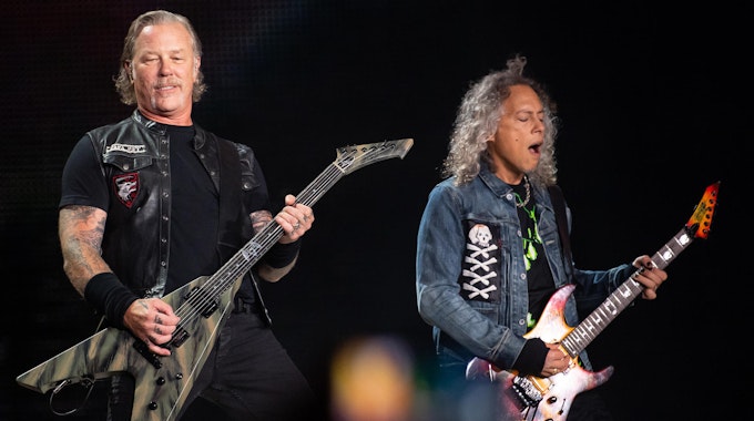Zwei Bandmitglieder von Metallicas stehen auf der Bühne und spielen E-Gitarre.