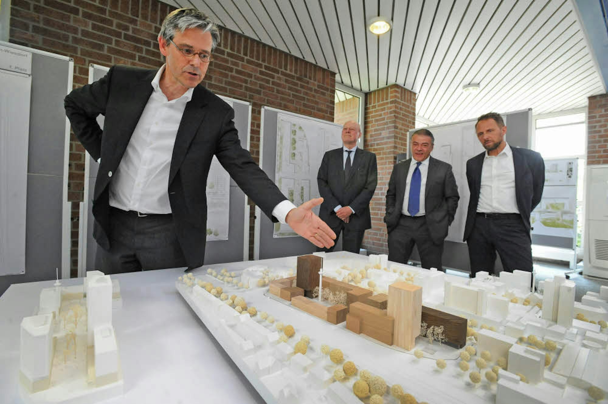 Ferdinand Heide erläutert seinen Entwurf im Modell vor Jury-Präsident Kaspar Kraemer, Investor Gerd Esser und OB Uwe Richrath (v.l.).