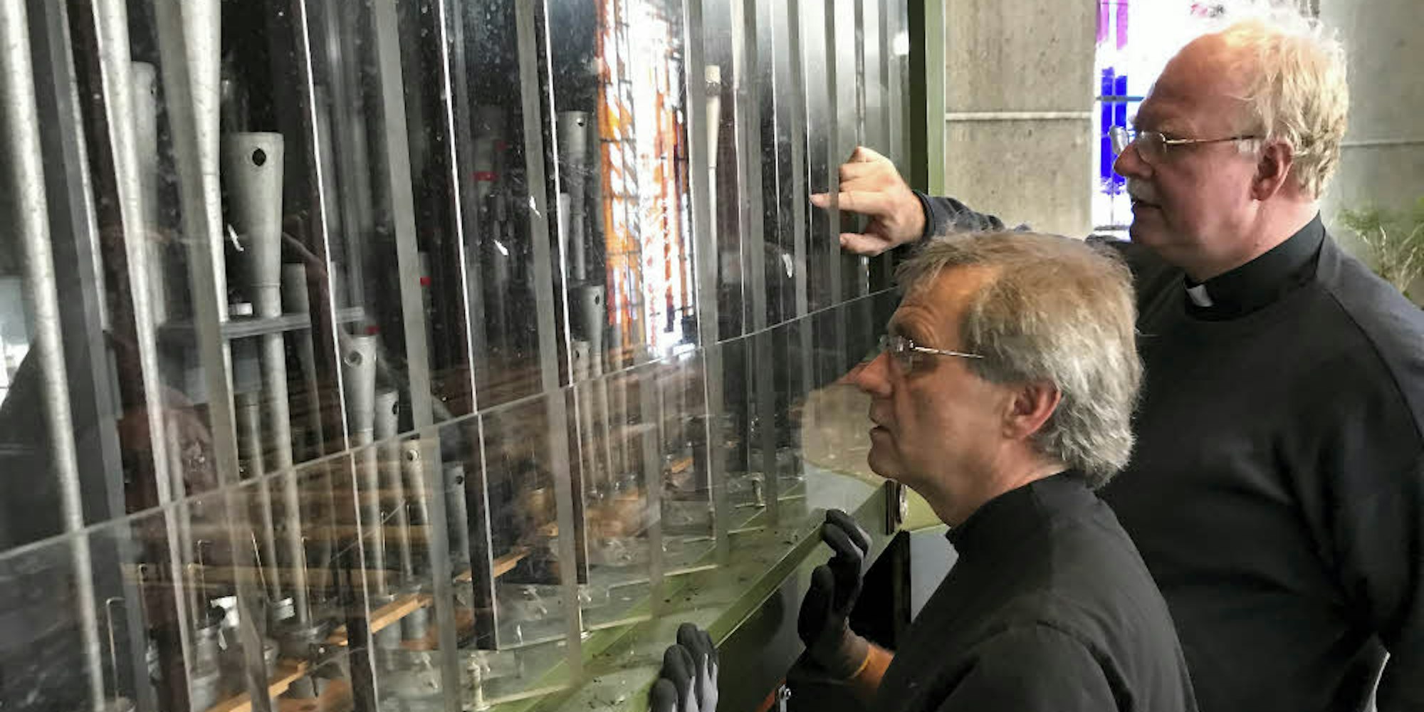 Nachdem Brandermittler das Instrument untersucht hatten, nahm Orgelbaumeister Ralf Müller (vorne) den Schaden gemeinsam mit Pfarrer Christoph Bersch in Augenschein.
