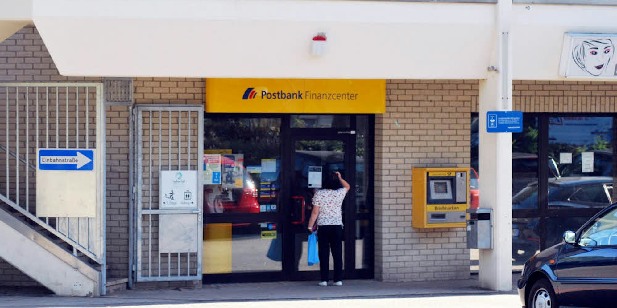 Eine Kundin erfährt durch den Aushang, dass die Postbank am Winkelpfad diese Woche nicht öffnet.