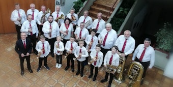 Die Mitglieder des Posaunenchors haben ihre Instrumente in der Hand.