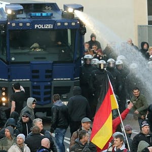 Mit einem Wasserwerfer drängen Polizisten die Kundgebungsteilnehmer in Köln zurück.