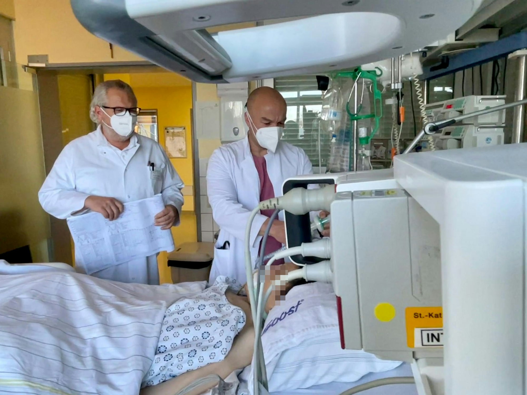 Oberarzt Dr. Thomas Wyderka (l.) und Intensiv-Mediziner Dr. Dorin Goia stehen am Bett eines Corona-Patienten, der schwere Organschäden davon trug.