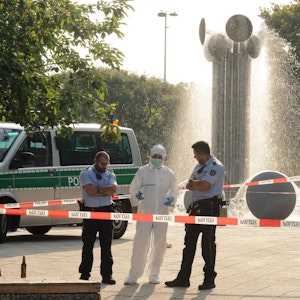 Einsatzkräfte und Spurensicherung stehen am Brunnen am Ebertplatz in Köln.