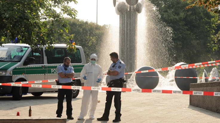 Einsatzkräfte und Spurensicherung stehen am Brunnen am Ebertplatz in Köln.