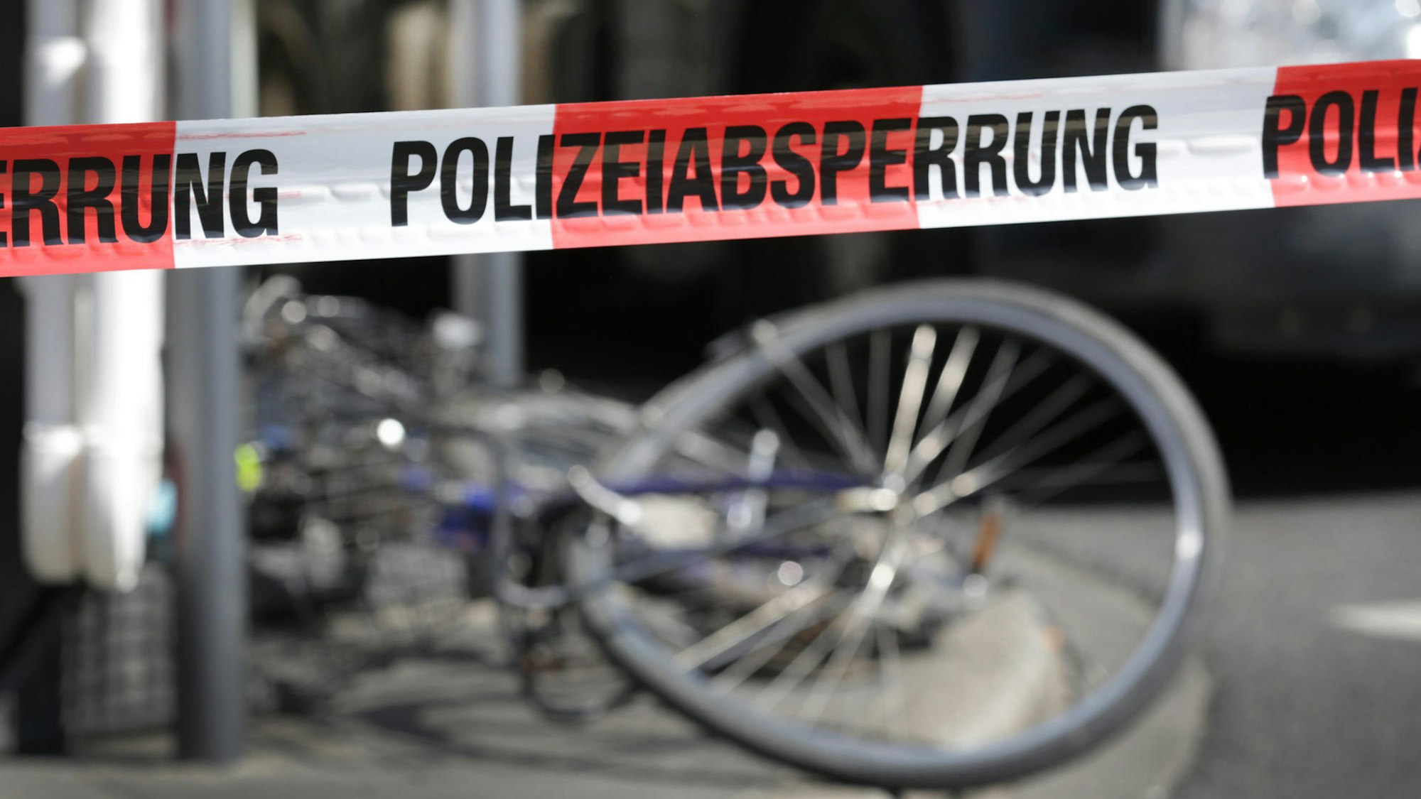 Das Bild zeigt ein verbogenes Fahrrad in einem abgesperrten Bereich der Polizei.