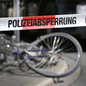 Das Bild zeigt ein verbogenes Fahrrad in einem abgesperrten Bereich der Polizei.