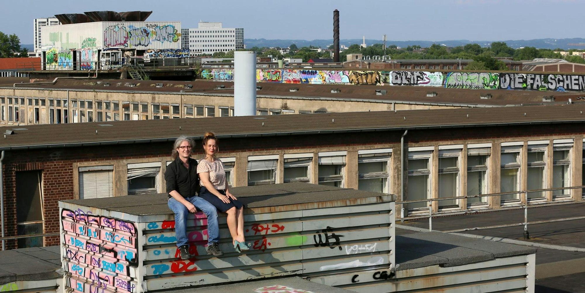 Marc Leßle (l.) und Anja Kolacek (r.) auf dem Dach der ehemaligen KHD-Hauptverwaltung; im Hintergrund Teile des riesigen Mülheimer Areals, aus dem ein neuer Stadtteil wird.