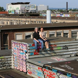Marc Leßle (l.) und Anja Kolacek (r.) auf dem Dach der ehemaligen KHD-Hauptverwaltung; im Hintergrund Teile des riesigen Mülheimer Areals, aus dem ein neuer Stadtteil wird.