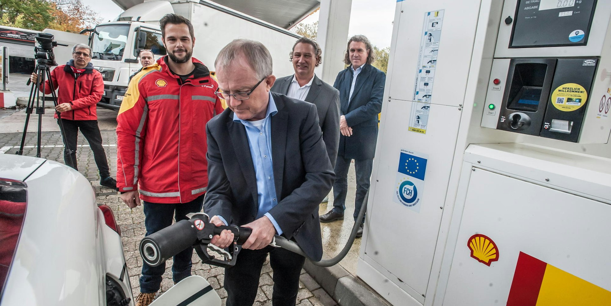 NRW-Abgeordneter Rüdiger Scholz tankt ein mit einer Brennstoffzelle betriebenes Auto an Leverkusens erster Wasserstofftankstelle.