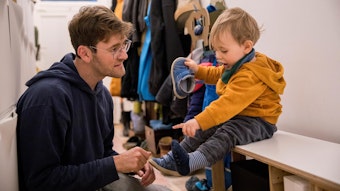 Janis Morgenthaler hilft seinem Sohn, die Schuhe anzuziehen.
