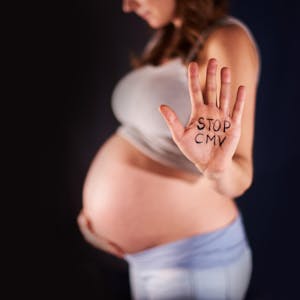 Hand einer Schwangeren mit dem Schriftzug "Stopp CMV"