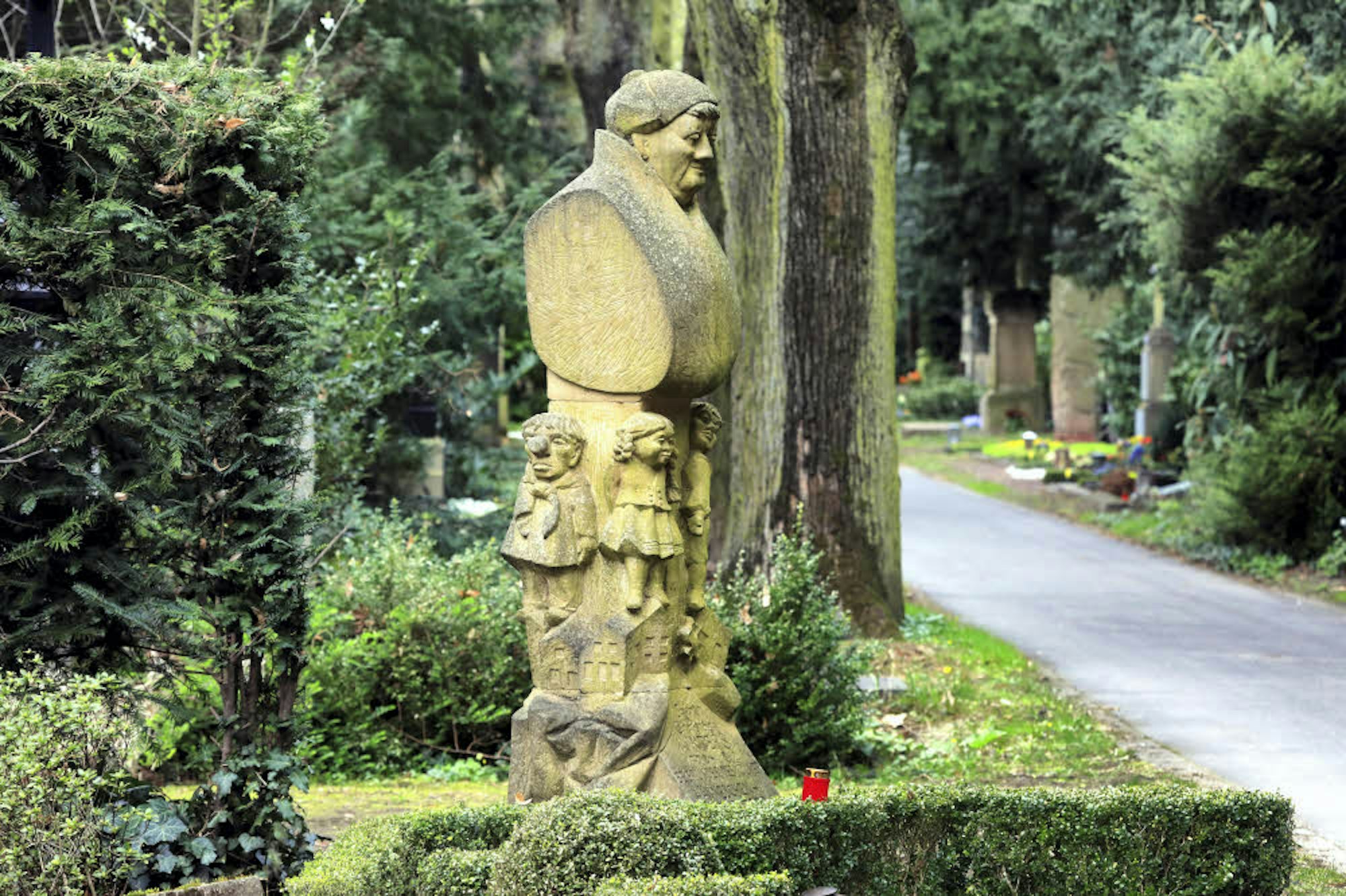 Ein Sandsteindenkmal für den Hänneschen-Gründer auf dem Kölner Melatenfriedhof.