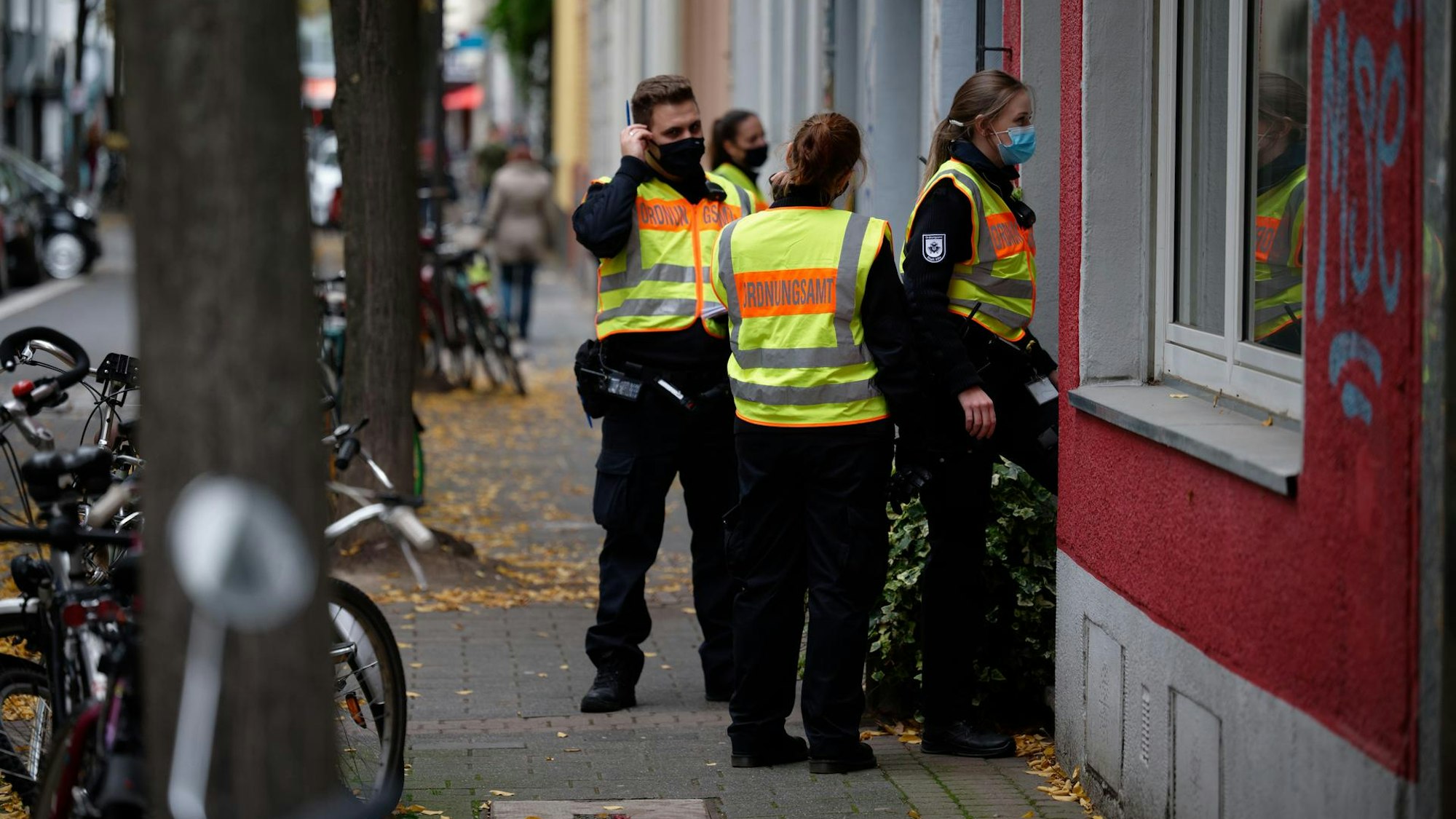Mehrere Mitarbeiterinnen und Mitarbeiter des Kölner Ordnungsamtes stehen vor einem Haus.