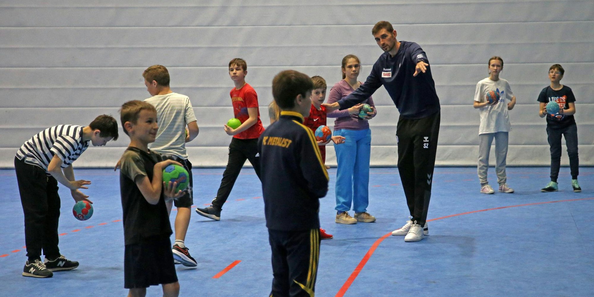 Geduldig erklärt Stanislav Zhukov den Mädchen und Jungen die Grundzüge der für sie unbekannten Sportart Handball.
