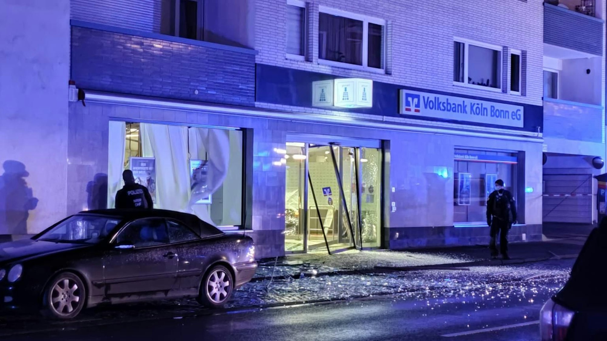 Zerplatzte Scheiben einer Volksbankfiliale in Köln-Brück nach einer Geldautomaten-Sprengung im Dezember 2021.
