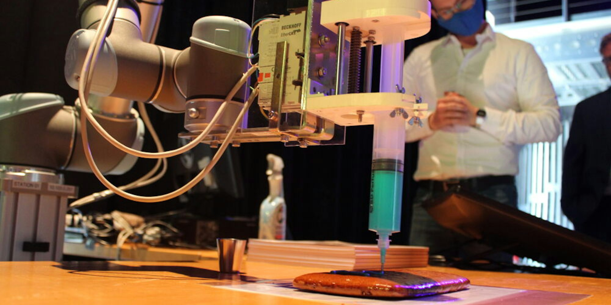 Künstliche Intelligenz: Der Roboterarm glasiert eine Aachener Printe.