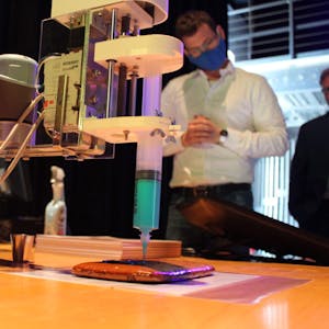 Künstliche Intelligenz: Der Roboterarm glasiert eine Aachener Printe.