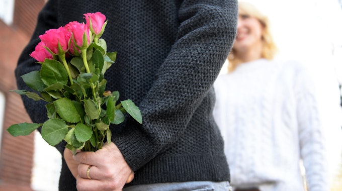 Mann überrascht Frau mit Blumenstrauß