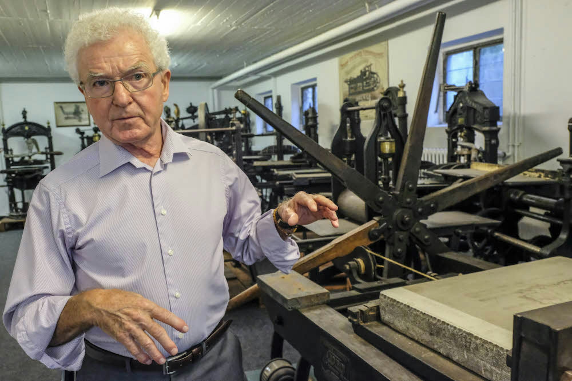 Uwe H. Breker stellt eine alte Druckpresse vor.