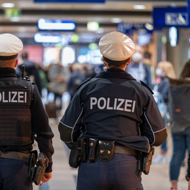 Zwei Beamte der Polizei gehen durch den Hauptbahnhof Köln.