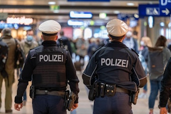Zwei Beamte der Polizei gehen durch den Hauptbahnhof Köln.