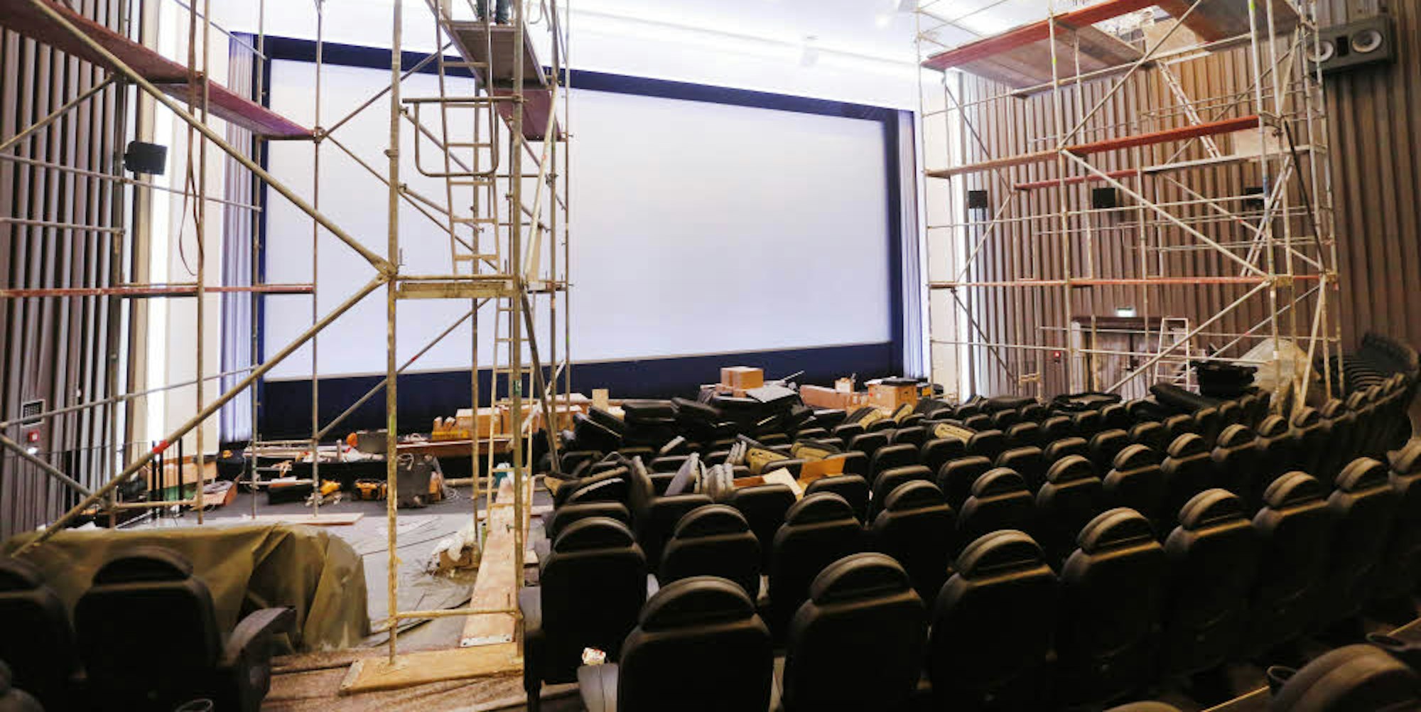 Im großen Saal des Filmpalast mit seiner hohen, geschwungenen Decke montieren Arbeiter noch zwei Kronleuchter.