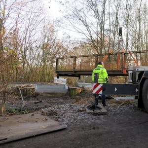 Ein 60-Tonnen-Kran setzt die neue Brücke in die zuvor hergerichteten Fassungen. Diese werden anschließend noch mit Mörtel aufgefüllt.