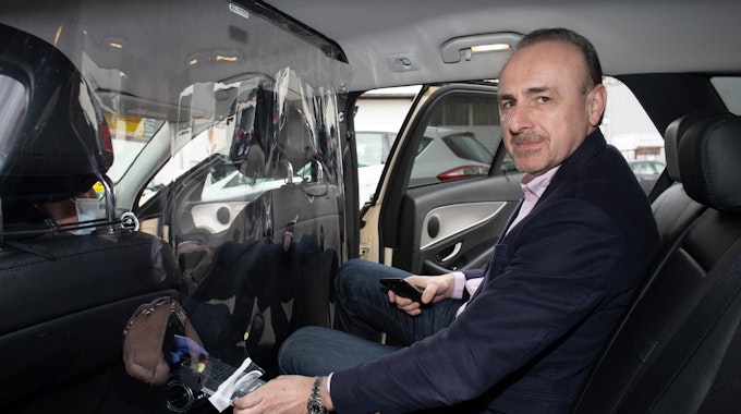 Der Kölner Taxi-Ruf-Chef Aleksandar Dragicevic sitzt in einem Auto.