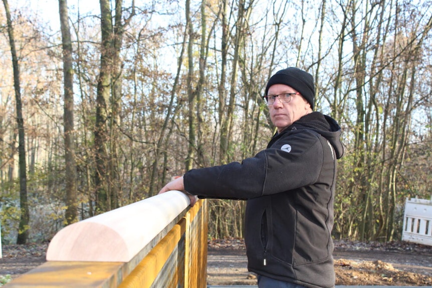 Clemens Jacobs von der Firma CJ Stahlbau passt Lärchenbalken am Geländer an.