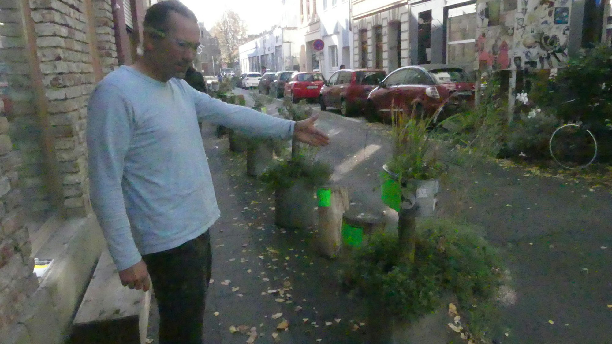 Jan-Marc Kutscher zeigt die mit Knöllchen beklebten Pflanzgefäße in der Körnerstraße.
