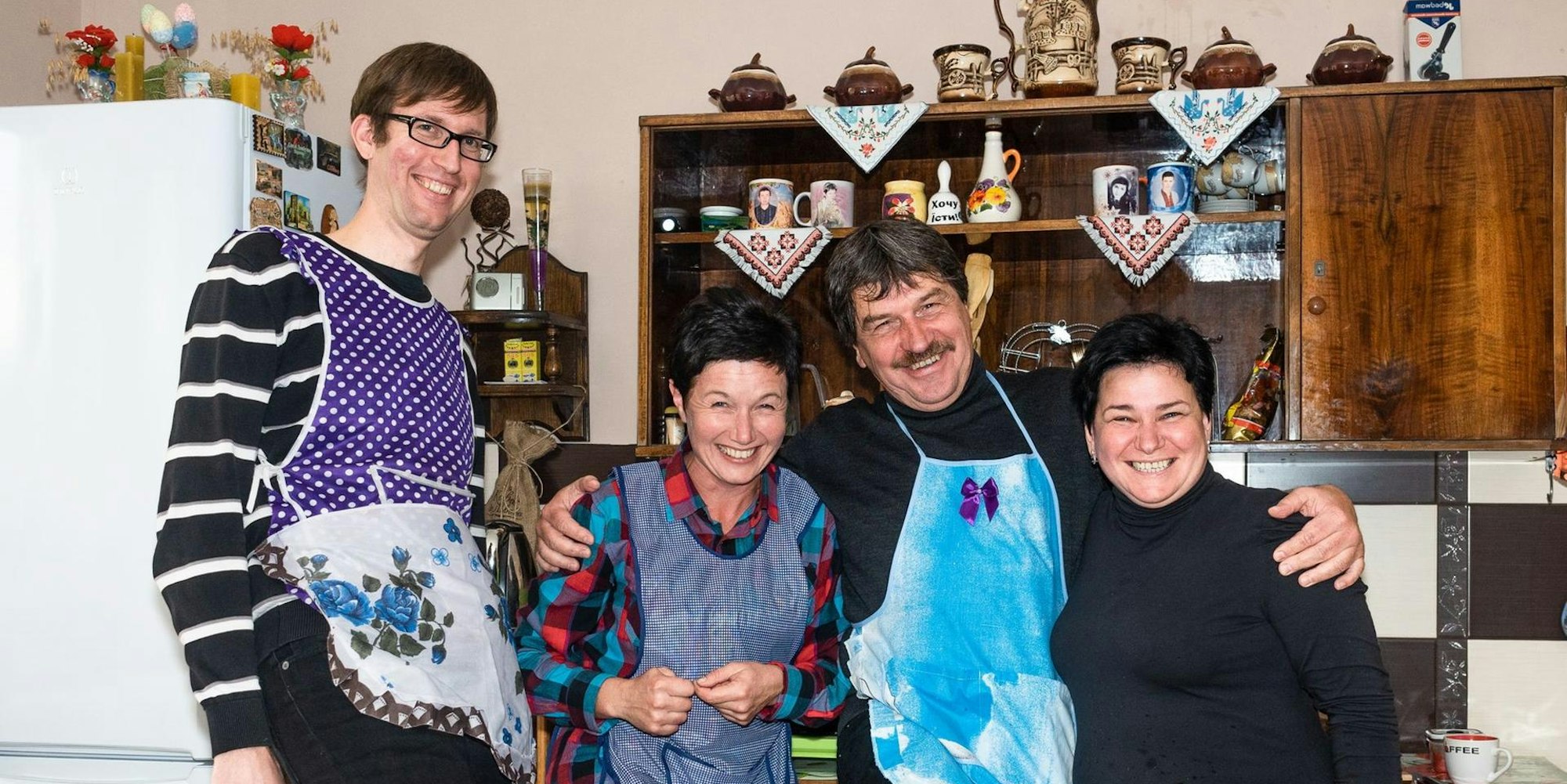 Stephan Hahn und Michael Kamp (l. und 3.v.l.) kochen mit zwei Frauen aus der Ukraine.