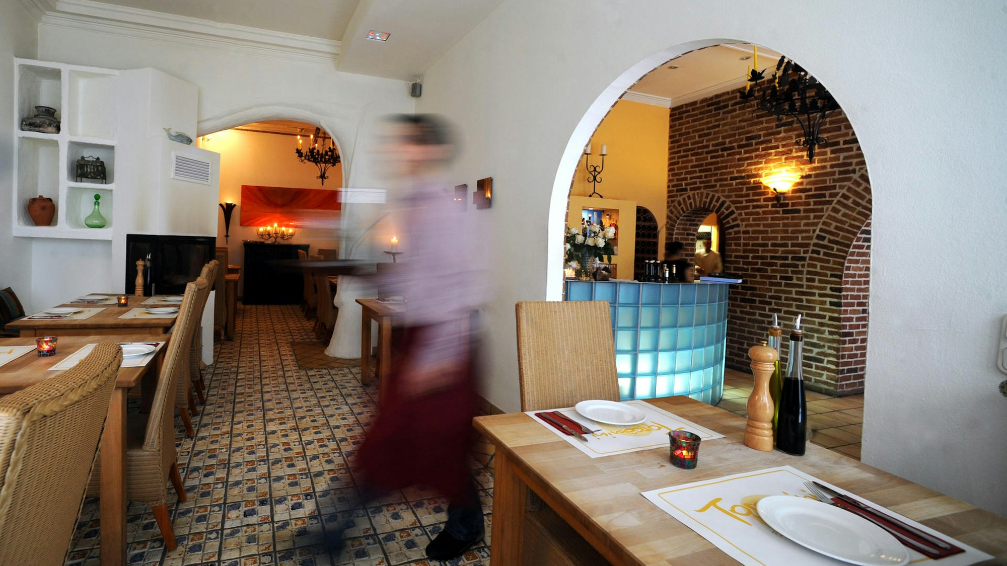 Ein Kellner geht durch das gemütliche Restaurant Toscanini.