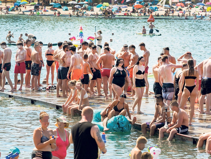 Menschen baden dicht an dicht am Fühlinger See.